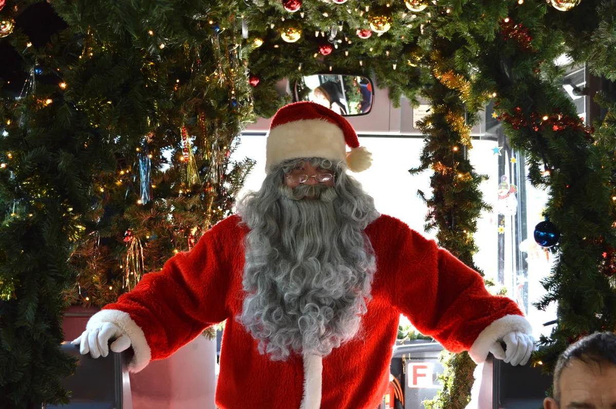 Ein Samichlaus steht im geschmückten Bus.